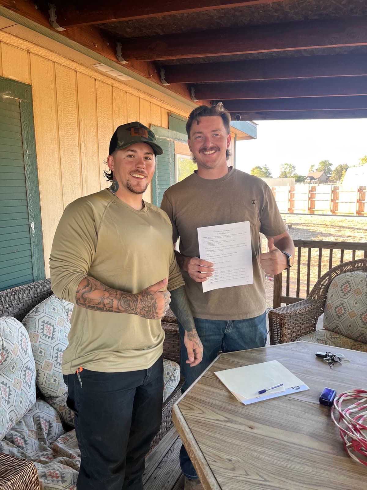 Jared Farney and Aaron Ward holding their signed business agreement